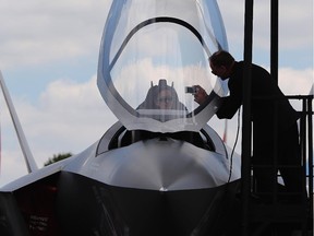 A man sits in a model of a Lockhead Martin F-35 on display on day four of the Farnborough International Airshow on July 16, 2014 in Farnborough, England.