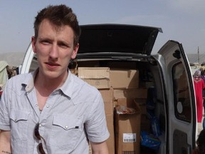 This undated file photo provided by the Kassig Family shows Peter Kassig standing in front of a truck filled with supplies for Syrian refugees. A new graphic video purportedly produced by Islamic State militants in Syria released Sunday Nov. 16, 2014 claims U.S. aid worker Kassig was beheaded.