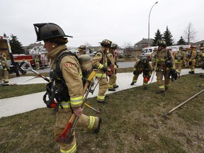 Firefighters respond to a working fire at the Lao Village Housing Co-operative community centre at 10 Bridgestone Drive in Kanata, on Nov. 29, 2014.
