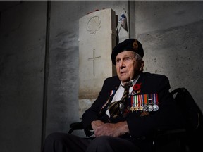 Standalone: Second World War Veteran Fred Arsenault, 94, of Toronto, gets his photograph taken as people wait for the sun to hit the headstone from the grave of Canada's Unknown Soldier in the Memorial Hall at the Canadian War Museum in Ottawa on Monday, Nov. 10, 2014.