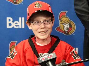 Late general manager of the Ottawa Senators, Bryan Murray, Pierre Dorion and Randy Lee, sign Jonathan Pitre as a pro scout for one day at the Canadian Tire Centre in Ottawa, November 20, 2014.