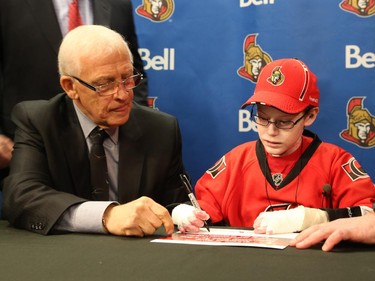 General manager of the Ottawa Senators, Bryan Murray, left, signs Jonathan Pitre as a pro scout for one day.