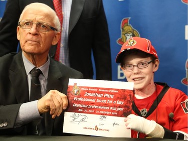 Late general manager of the Ottawa Senators, Bryan Murray signs Jonathan Pitre as a pro scout for one day at the Canadian Tire Centre in Ottawa, November 20, 2014.