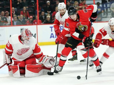 Goalie Jimmy Howard keeps his eye on the puck while Kyle Turris to get a handle on it in the first period.