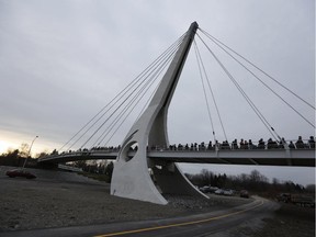 Hundreds of people cross the newly opened Airport Parkway Pedestrian Bridge on Nov. 29, 2014.