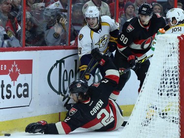 Jared Cowen, left, and Alex Chiasson, right, of the Ottawa Senators fights for the puck against Carter Hutton of the Nashville Predators during first period NHL action.