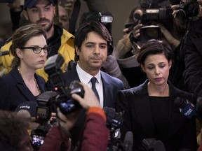 Jian Ghomeshi makes his way through a mob of media with his lawyer, Marie Henein (right), at a Toronto court Wednesday.