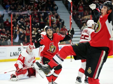 Jimmy Howard looks down as Mike Hoffman, centre, and Patrick Wiercioch, right, celebrate the game winning goal in the third period.