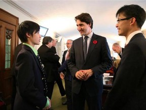 New MP Arnold Chan, right, introduces Liberal leader Justin Trudeau to his son, Nathaniel, this week.