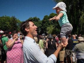 Liberal Leader Justin Trudeau balances his 5-month-old son Hadrien on his hand while attending the B.C. Day Liberal barbeque in Vancouver, B.C., on Monday August 4, 2014.