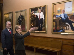 Ontario Premier Kathleen Wynne shows Quebec Premier Philippe Couillard artwork in the hallway outside her office at the Ontario Legislature in Toronto.