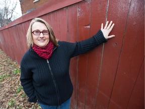 Laurie Kingston stands at her fence that runs along her property at Bronson Avenue and Fourth Avenue. Fed up with having to paint it every time someone tagged it with graffiti, (nine time last summer) she applied to the city to have a mural painted on it, hoping it will dissuade the vandalism.