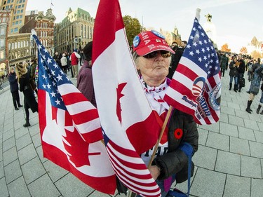 Lucille Gilbert proudly shows off her Canadian, American and Quebec flags as the annual Remembrance Day Ceremony takes place at the National War Memorial in Ottawa.