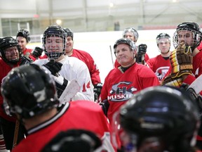 Mike Hayes, centre, listens in at the start of the Sacred Heart Varsity Hockey Team Alumni Exhibition Game in memory of Mike's son Connor Hayes, who tragically died last year in a New Zealand landslide.