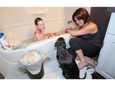 Molly, the family's other Pug/Terrier mix, lightens the mood at bath time.