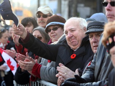 Moved to tears as the veterans passed by, Dave Collins, tips his hat as a gesture of thanks to them from the crowd. Remembrance Day at the National War Memorial in Ottawa November 11, 2014.