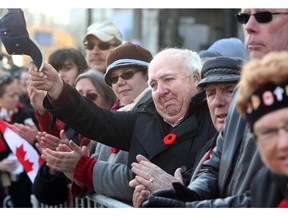 Moved to tears as the veterans passed by, Dave Collins, tips his hat as a gesture of thanks to them from the crowd during Remembrance Day at the National War Memorial in Ottawa November 11, 2014.