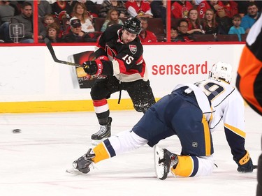 Zack Smith #15 of the Ottawa Senators shoots the puck against Roman Josi #59 of the Nashville Predators.