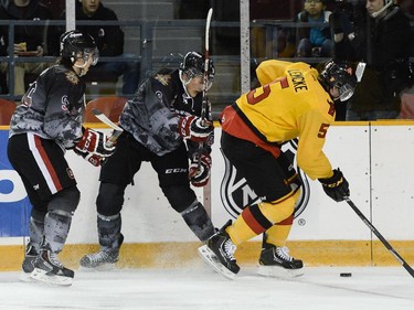 Belleville Bulls defenceman #5 Justin Lemcke skates away from two Ottawa 67's players.