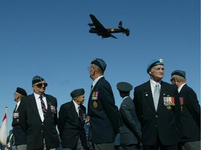 Royal Canadian Air Force Vets stand on parade as a Second World War Lancaster bomber flies past during a Battle of Britain memorial at the Canadian Aviation Museum in 2004.