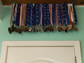 A collection of medals is displayed above the door of an athlete’s room