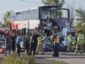 Firefighters and police search at the scene of a horrific crash between an OC Transpo double decker bus and a Via train near the Fallowfield station in Barrhaven in September 2013.