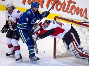 Ottawa Senators goalie Craig Anderson (41) tries to clear Vancouver Canucks left wing Alex Burrows (14) from in front of the net as Ottawa Senators defenseman Erik Karlsson (65) looks on during second period NHL action in Vancouver, B.C. Tuesday, Nov. 11, 2014.