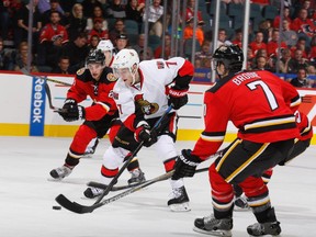 Kyle Turris #7 of the Ottawa Senators skates against Sean Monahan #23 and TJ Brodie #7 of the Calgary Flames at Scotiabank Saddledome on November 15, 2014 in Calgary, Alberta, Canada.