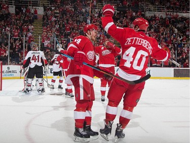 Gustav Nyquist #14 of the Detroit Red Wings celebrates his first period goal with teammate Henrik Zetterberg #40.