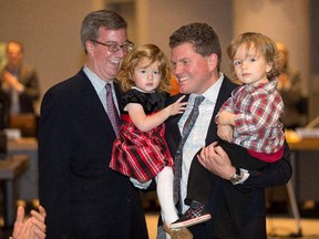 Outgoing Ottawa city councillor Steve Desroches is upstaged by his two year old twins Zoe, left, and Max, with Mayor Jim Watson looking on, while he gives his goodbye speech during the council meeting Wednesday morning.