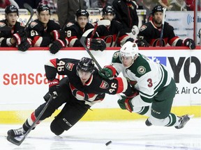 Patrick Wiercioch (46) of the Ottawa Senators battles for the pucks with Minnesota Wild's Charlie Coyle (3) during NHL game action.