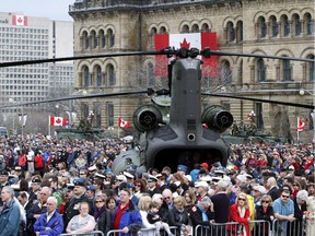 People gather around a Chinook helicopter on Parliament Hiil in Ottawa during ceremonies for Canada's National Day of Honour Friday May 9, 2014.