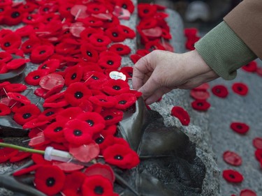 People place poppies at the Tomb of the Unknown Soldier following the Remembrance Day ceremony at the National War Memorial in Ottawa on Tuesday, Nov. 11, 2014.