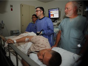 A doctor and nurses use a colonoscope on a patient during a colonoscopy at Naval Medical Center San Diego.