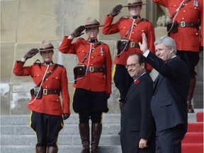 Canadian Prime Minister Stephen Harper, right, greets French President Francois Hollande, centre, on Parliament Hill in Ottawa on Monday, Nov. 3, 2014.