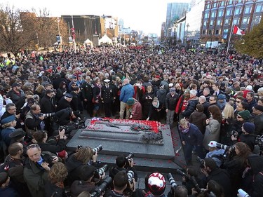 Thousands of people gather to pay their respects at the tomb of the unknown soldier after the Remembrance Day ceremony at the National War Memorial in Ottawa Tuesday, November 11, 2014.