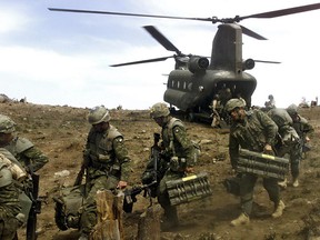 Tora Bora region, Afghanistan. 7 May 2002- High in the mountains, soldiers of the 3rd Battalion, Princess Patricia's Canadian Light Infantry (3 PPCLI) Battle Group disembark from a US Army CH-47D Chinook helicopter carrying demolition equipment and the massive explosive charges fired by the Carl Gustav 84-mm recoiless rifle. (Photo by Cpl Lou Penney, 3 PPCLI Battle Group)