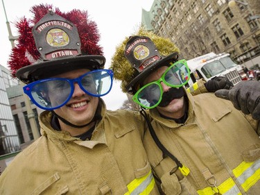 Two Ottawa firefighters collect toys and and hand out candy canes during the 2014 Ottawa Professional Fire Fighters' Association's Help Santa Toy Parade in Ottawa Saturday