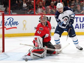 OTTAWA, ON - NOVEMBER 8: Craig Anderson #41 of the Ottawa Senators makes a pad save as Bryan Little #18 of the Winnipeg Jets looks for the rebound during an NHL game at Canadian Tire Centre on November 8, 2014 in Ottawa, Ontario, Canada.