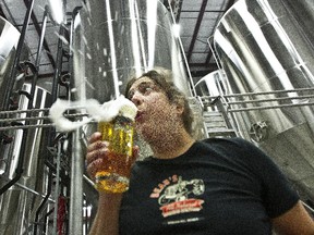 Jennifer Beauchesne of Beau's Brewery on Terry Fox Drive blows the head off a freshly poured beer in this 2013 file photo.