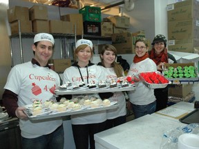 Volunteers for Cupcakes 4Christmas show off some of the more than 3,000 red, green and white goodies that will cap the Mission's annual Christmas Dinner this Sunday.