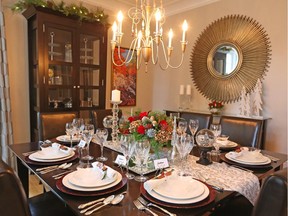 The lavish centrepiece contains red roses, fresh greenery, silver and gold pine cones and gold hydrangea. Silver figurines, crystal stemware and glass candlesticks add more glamour.