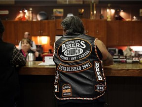 A church-goer displaying all his patches waits for a drink by the cafe bar during a service at the Capital Biker's Church.