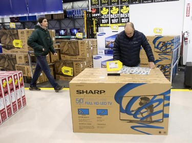 A man browses through a flyer at Best Buy on Merivale Road on Boxing Day, Dec. 26, 2014.