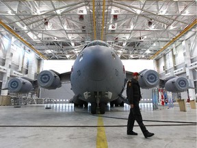 A military police officer walks near a C-17 Globemaster cargo plane after Minister of Defence Rob Nicholson made an announcement at CFB Trenton Friday that Canada will be getting a fifth C-17 Globemaster cargo airplane.