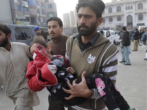 A Pakistani girl, who was injured in a Taliban attack in a school, is rushed to a hospital in Peshawar, Pakistan, Tuesday, Dec. 16, 2014. Taliban gunmen stormed a military-run school in the northwestern Pakistani city of Peshawar on Tuesday, killing and wounding scores, officials said, in the highest-profile militant attack to hit the troubled region in months.(AP Photo/Mohammad Sajjad)   // fo121714-taliban