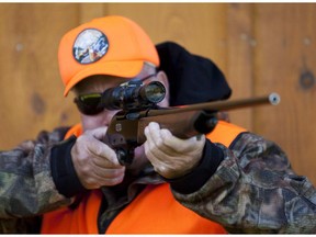 A rifle owner checks the sight of his rifle at a hunting camp property in rural Ontario west of Ottawa in this file photo.