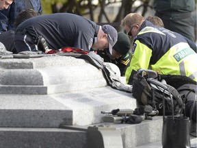 A soldier, police and paramedics tend to Cpl. Nathan Cirillo at the National War Memorial near Parliament Hill in Ottawa on Wednesday Oct. 22, 2014.