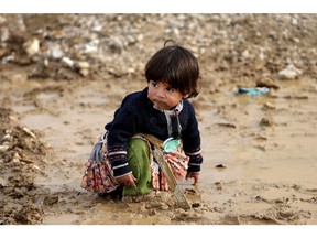 A Syrian refugee girl sits on mud at a refugee camp, in the eastern Lebanese Town of Al-Faour near the border with Syria, Lebanon, Tuesday, Dec. 2, 2014. Syrian refugees in Lebanon reacted with panic Tuesday to news that the U.N. was suspending aid to 1.7 million refugees due to lack of funds a decision officials said threatens to starve thousands of families and add pressure on already strained hosting countries.