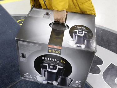 A woman carries her new Keurig coffee maker, a Boxing Day purchase from Best Buy on Merivale Road.